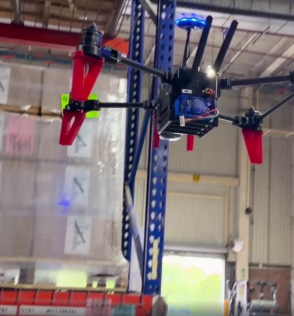 Air Hive drone flying between warehouse racks, capturing inventory
